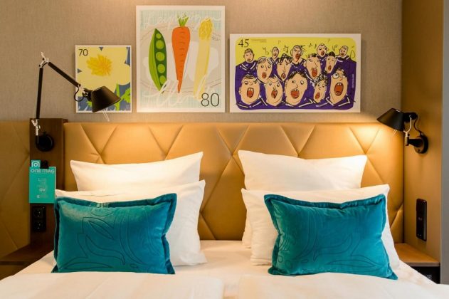 Über dem Bett befinden sich stilisierte Briefmarken. Bild: Motel One