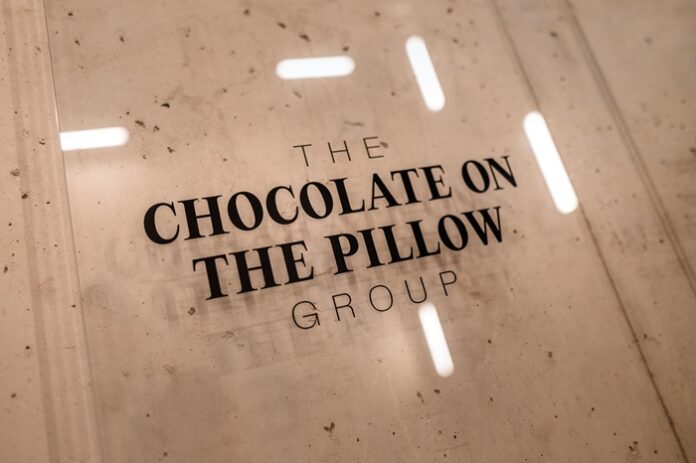 Schriftzug The Chocolate on the Pillow Group auf einem Schild