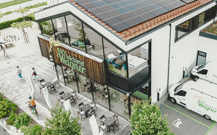 Luftaufnahme Geschäft mit installierten Wallbox-Ladestation für Elektroautos auf den Parkplätzen.