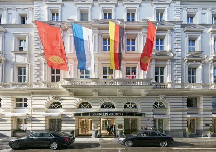 Gebäude mit Neorenaissancefassade mit verschiedenen Flaggen vor dem Eingang