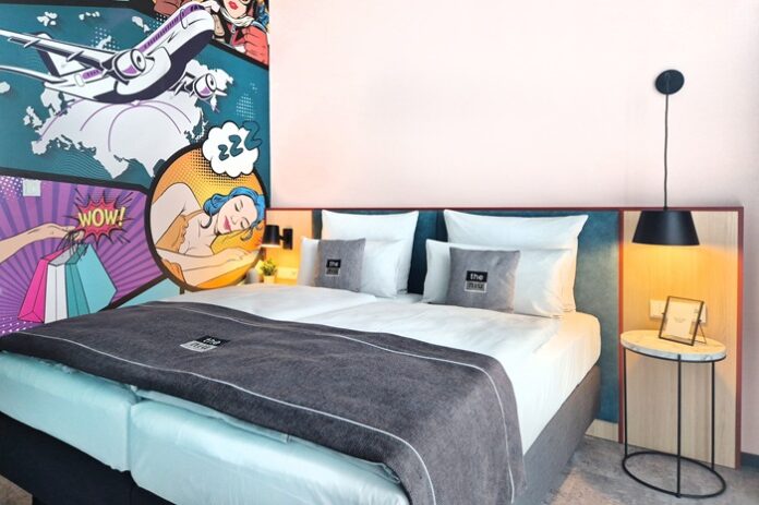 Doppelbett neben Wand mit Comic-Design