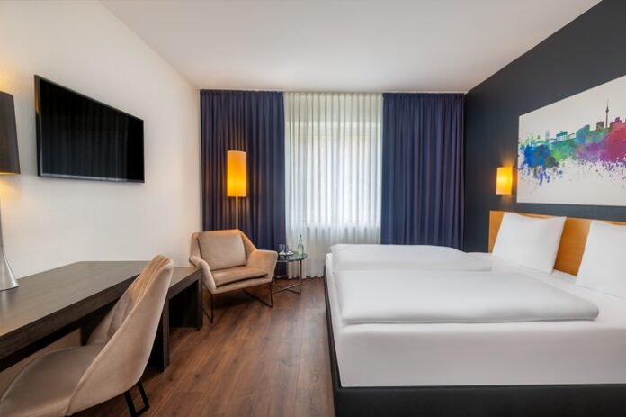 Zimmer mit Doppelbett, Sessel und Schreibtisch