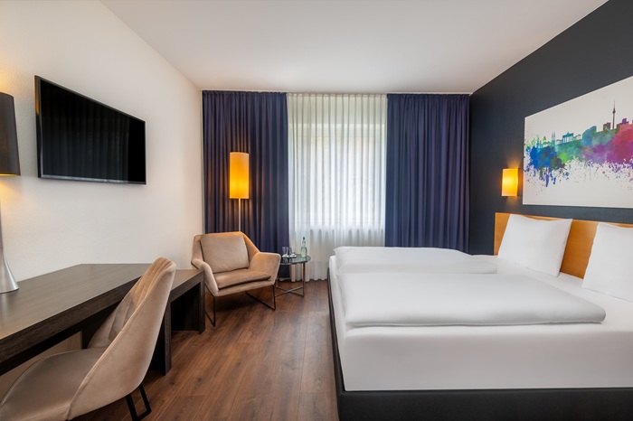 Zimmer mit Doppelbett, Sessel und Schreibtisch