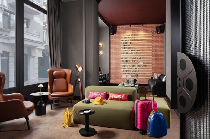 Raum mit Sofas und Ledersesseln und mit Schrift gestalteter Wand