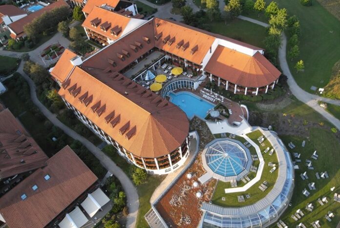 U-förmiges Gebäude mit rundem Pool aus der Vogelperspektive