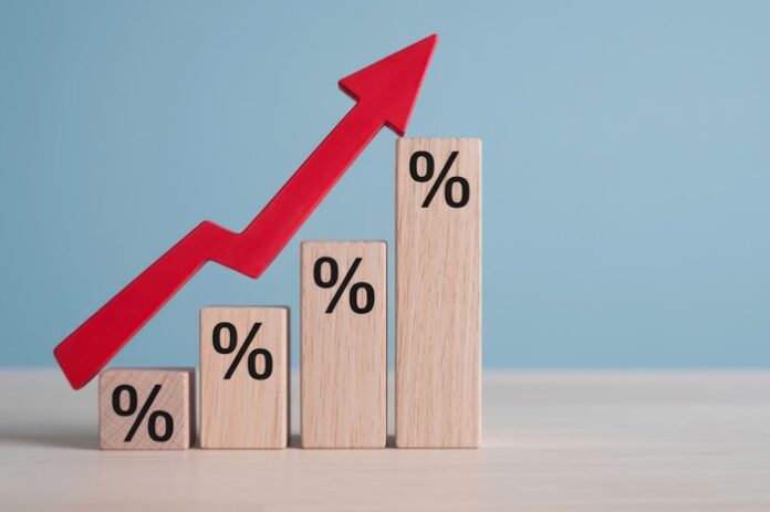 Holzklötzchen unterschiedlicher Größe mit Prozentzeichen und nach oben zeigendem Pfeil