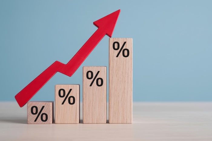 Holzklötzchen unterschiedlicher Größe mit Prozentzeichen und nach oben zeigendem Pfeil