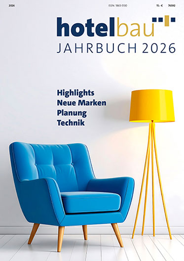 Hotelbau Jahrbuch 2026 cover featuring a blue armchair and a yellow floor lamp against a white wall; text reads Highlights, Neue Marken, Planung, Technik.
