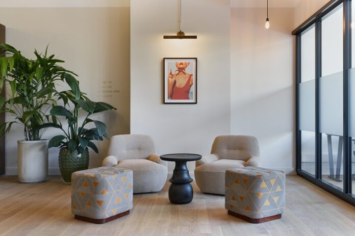 Moderne rundliche Sessel und Hocker um einen kleinen runden Tisch