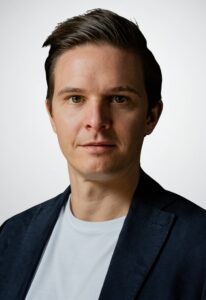 Junger Mann mit weißem Tshirt und dunklem Jacket