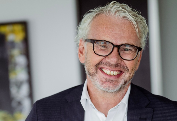 Grauhaariger Mann mit Bart und dunkler Brille