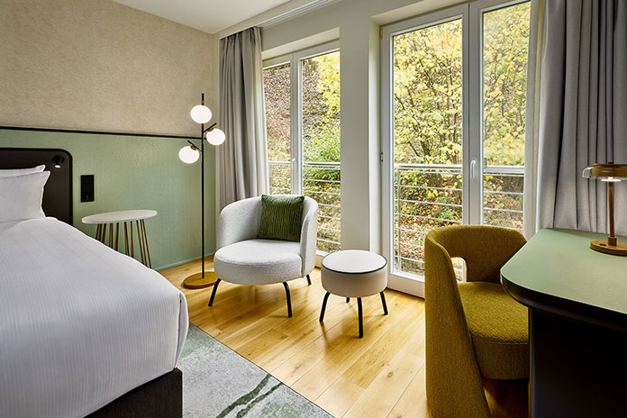 MokeUp eines modernen Hotelzimmers mit Sitzbereich, Schreibtisch und natürlicher Farbgestaltung nach Hospitality-Design-Konzept