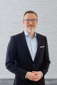 Mann mit Brille und dunklem Jacket