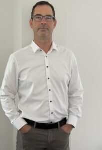 Mann mit dunklem Haar und weißem Hemd