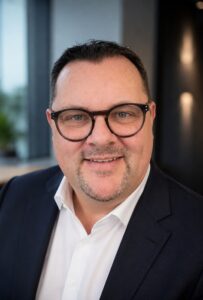 Mann mit dunklem Jacket und Brille